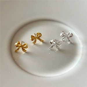 Detail view of 925 sterling silver bow knot stud earrings in gold and silver finishes
