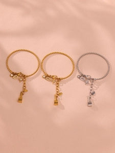 Detailansicht der gold- und silbernen Armbänder mit Stern- und Lippenstiftanhängern