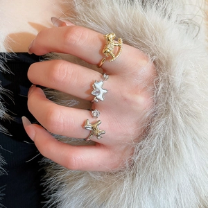 Detail showing gold rocking horse and silver butterfly zircon rings on model's fingers