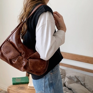 Retro brown leather baguette bag with pleated details and adjustable strap on model
