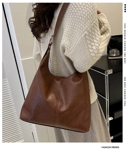 Brown soft leather tote bag with center seam detail shown as a large shoulder bag