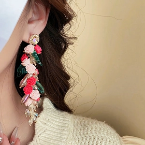 Boucles d'oreilles vintage avec glands à fleurs roses et perles sur un modèle