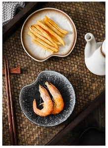 Close-up of Japanese ceramic appetizer plates with irregular shapes in a zen setting