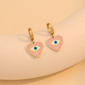 Boucles d'oreilles cœur en or, émail rose et œil maléfique sur support beige élégant