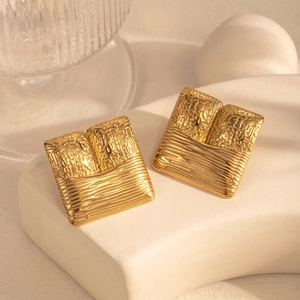 Minimalist rectangular gold earrings with split texture on white geometric stand