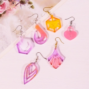 DIY heart and teardrop resin earrings in purple and orange on floral background
