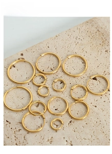 Macro shot of multiple sizes of polished gold-plated titanium steel hoop earrings set