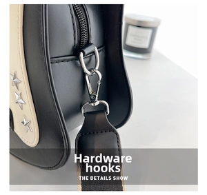 Close-up of silver hardware, star studs, and black-white woven strap on guitar bag