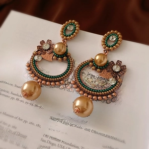 Boucles d'oreilles fleur vintage avec perles champagne et perles vertes sur livre