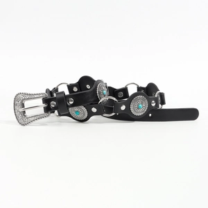 Detail of vintage punk belt featuring turquoise conchos and ornate silver buckle