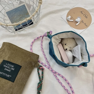 Corduroy phone bag detail showing spacious interior with beauty items and woven straps
