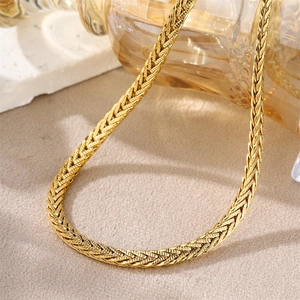 Macro detail of gold plated snake bone chain showing woven texture and fine metallic finish