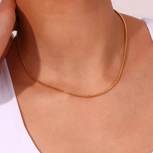 Detail of delicate 18K gold plated stainless steel box chain necklace on neck