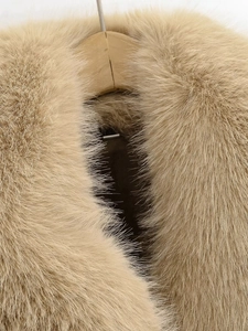 Gros plan du col en fourrure synthétique moelleuse sur une veste en cuir marron