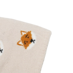 Detailed close-up of soft beige knit fabric featuring a cute orange fox embroidery