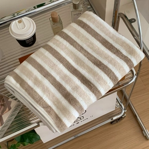 Close-up of thick striped bath towel folded on a cart with cozy home lifestyle decor