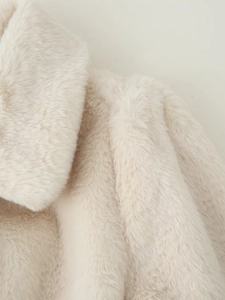 Detail shot of plush faux fur texture on beige coat collar showing soft thick material