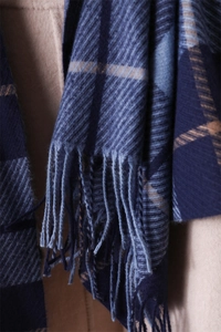 Detailed macro view of the soft plaid scarf texture and fringe tassel edge