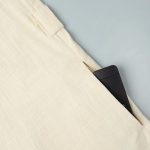 Detail of side-seam pocket on sleeveless beige linen dress showing functional depth