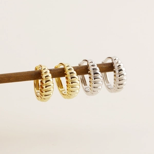 Detailed view of gold and silver S925 sterling silver croissant hoop earrings