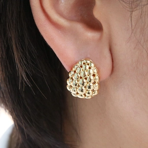 Detailed close-up of a 18K gold beaded dome stud earring worn by a model
