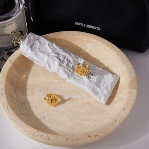 Elegant gold daisy flower clip-on earrings set displayed on a luxury marble tray