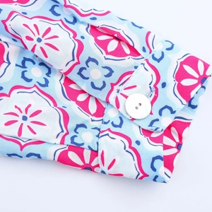 Detail of floral print midi dress cuff with geometric pattern and white button