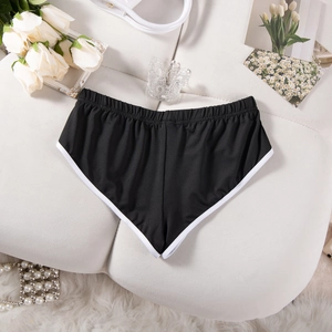 Flachbild von schwarzen Yoga-Shorts mit weißem Rand und dekorativen Blumen