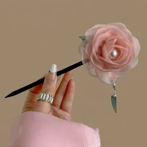 Detail of pink silk flower hair pin with white pearl accent and elegant tassel