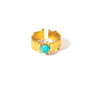 Close-up of golden geometric ring with turquoise stone inlay on a white background