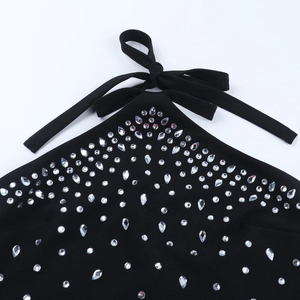 Détail macro du col licou et des strass scintillants sur la robe de soirée noire