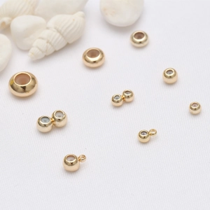 14k gold filled beads with silicone core for DIY jewelry making on white seashell