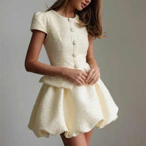 Dettaglio completo in tweed crema con top a maniche corte, volant e gonna svasata