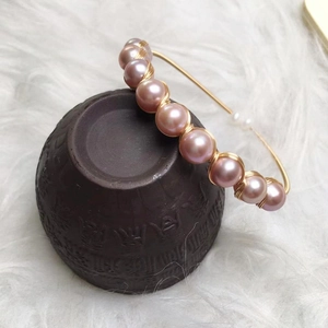 Detail of 14K gold-wrapped freshwater pearl bracelet with lavender purple pearls on a gold wire