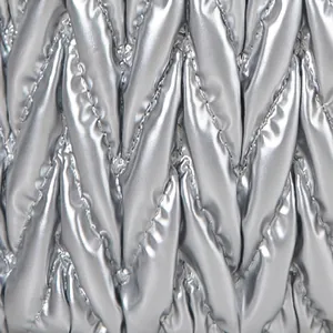 Dettaglio del tessuto in nylon trapuntato argento con trama intrecciata e doppia zip in metallo