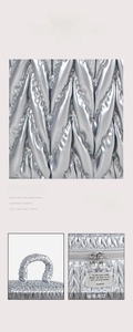 Close-up of silver quilted nylon fabric with woven texture and premium dual metal zippers