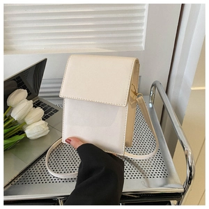 Petit sac bandoulière blanc en similicuir sur un chariot avec des tulipes