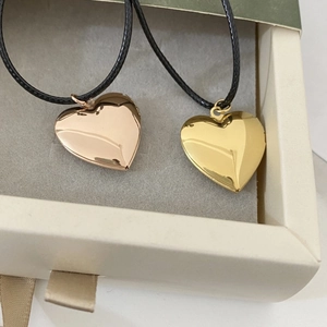 Close-up of gold and rose gold heart-shaped photo lockets in a jewelry gift box