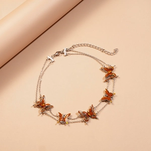 Detailed view of the double-layer silver chain with orange gradient butterfly charms