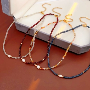 Detail of four colorful gemstone necklaces with freshwater pearls and gold lobster clasps