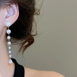 Detail of silver needle pearl tassel earrings with water drop zircon on model's ear