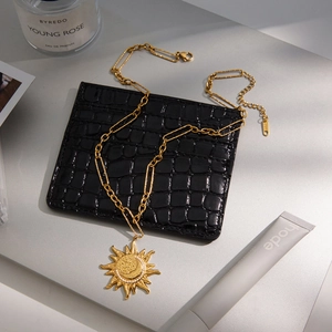 Gold sun and moon pendant necklace set on black leather, chic celestial jewelry