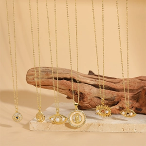 Gold plated necklaces with Evil Eye and Virgin Mary charms on natural stone surface