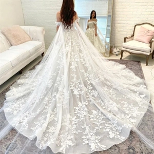 Elegant off-shoulder white lace wedding dress with long train and floral applique