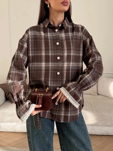 Detail of plaid long sleeve shirt with exquisite white lace cuffs and brown check pattern