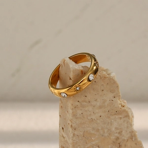 Macro detail of 18K gold plated stainless steel ring with zircon stones and floral engraving