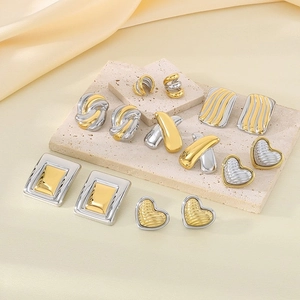 Elegant two-tone 18K gold plated heart and geometric earrings set on stone display
