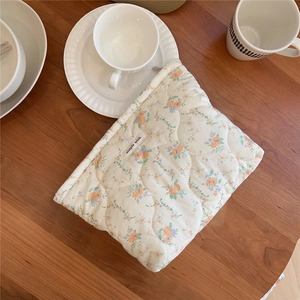 Close-up of quilted cotton makeup bag with orange floral patterns and simple wish label