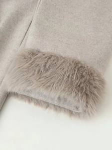 Close-up of light grey wool coat sleeve featuring soft faux fur trim and textured fabric