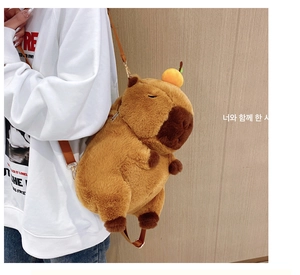 Detail of Capybara plush backpack with orange decoration and adjustable shoulder strap